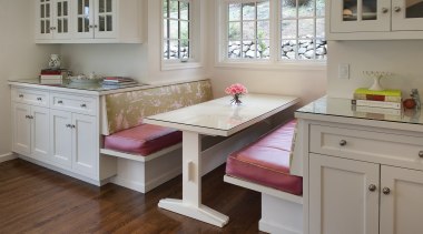 window seat with pink cushions, two seats face cabinetry, countertop, cuisine classique, floor, flooring, furniture, hardwood, home, interior design, kitchen, room, table, window, wood, wood flooring, gray, brown