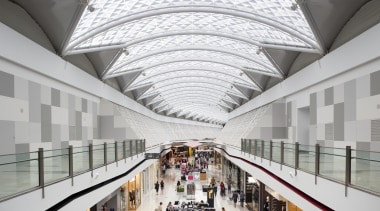 View of light toned interior of mall. - architecture, building, daylighting, metropolitan area, mixed use, shopping mall, tourist attraction, white, gray