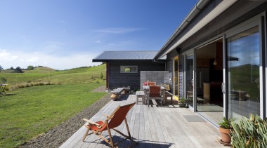 View of wooden patio with view out to architecture, backyard, cottage, estate, home, house, landscape, property, real estate, roof, sky