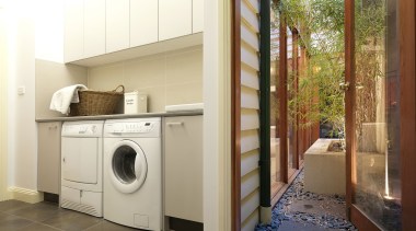 Laundry with grey tiled floor and white cabinets. home, home appliance, laundry, laundry room, major appliance, property, real estate, room, washing machine, white, brown
