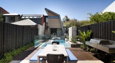 Outdoor patio area with table, blue cushioned seats architecture, backyard, estate, home, house, outdoor structure, property, real estate, residential area, roof, swimming pool, black, teal