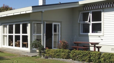 View of exterior with white cladding and lawn. cottage, estate, facade, farmhouse, home, house, porch, property, real estate, siding, window