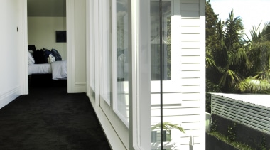 Hallway with black carpet and white walls. - architecture, daylighting, estate, home, house, interior design, property, real estate, window, gray, black