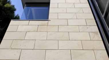 Low angle shot of exterior with light toned architecture, building, commercial building, daylighting, facade, floor, house, property, real estate, roof, siding, wall, window, white