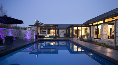 Night view of house from poolside. - Night architecture, estate, home, house, leisure, lighting, mansion, property, real estate, reflection, residential area, resort, resort town, sky, swimming pool, villa, blue, teal