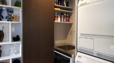 Bifolding doors conceal the ironing station and sink cabinetry, home appliance, kitchen, laundry, laundry room, major appliance, room, brown