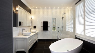 In this master bathroom, walls feature large tiles bathroom, home, interior design, property, real estate, room, sink, window, white, black
