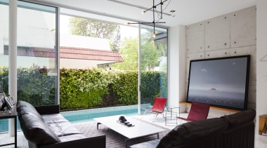 Exposed concrete walls add an industrial aesthetic to house, interior design, living room, property, real estate, table, window, gray, white