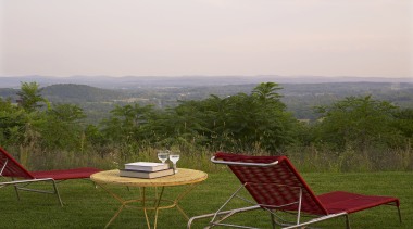 Sitting high on a natural plateau, this house chair, field, furniture, grass, grassland, house, landscape, leisure, meadow, outdoor furniture, plain, plant, rural area, sky, sunlounger, table, tree, brown, white