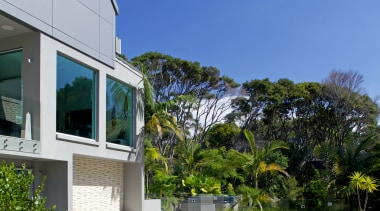 A swathe of green lawn surrounded by tall architecture, condominium, cottage, estate, home, house, leisure, mansion, property, real estate, residential area, resort, sky, swimming pool, vacation, villa, water, blue