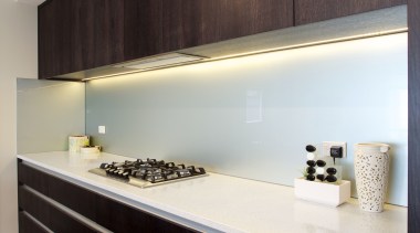 Dark-stained timber veneer cabinets line the rear wall architecture, floor, flooring, interior design, kitchen, room, wall, wood, gray, black