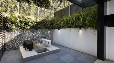 This sustainable house has vertical gardens integrated into architecture, backyard, courtyard, garden, home, house, outdoor structure, plant, property, real estate, wall, yard, gray, black