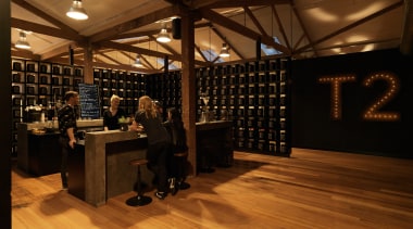 A former industrial warehouse in Melbourne is home floor, flooring, hardwood, interior design, liquor store, wood, wood flooring, brown, orange