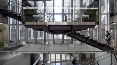 :The main circulation stair in this educational facility architecture, building, condominium, daylighting, glass, handrail, mixed use, stairs, structure, gray, black