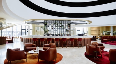 A curvaceous bar area provides the social focal ceiling, function hall, interior design, lobby, restaurant, table, white