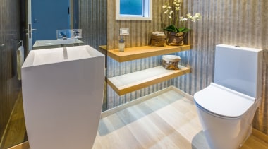 A wall-height smoked glass mirror behind the sculptural bathroom, floor, interior design, plumbing fixture, product design, room, toilet, toilet seat, gray