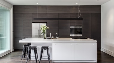 A cantilevered countertop end with four stools tucked cabinetry, countertop, cuisine classique, interior design, kitchen, gray, black