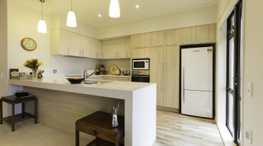 A waterfall-end countertop, ample storage and easy-to-use appliances countertop, cuisine classique, interior design, kitchen, real estate, room, orange, white