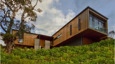 Seen from outside this home, the master suite architecture, cottage, estate, facade, farmhouse, grass, home, house, property, real estate, sky, tree, wood, brown