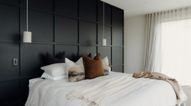 Master bedroom with black panelled wall/headboard. 
