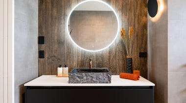 A striking rugged stone basin sits atop the 