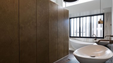 This metal-look dividing wall incorporates push-to-open cabinetry with brown