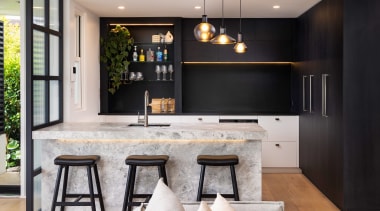 Concealed lighting accentuates the kitchen's various feature materials. 