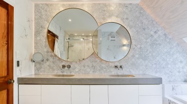 Two round mirrors are brought together in one architecture, bathroom, building, cabinetry, ceiling, countertop, floor, flooring, furniture, home, house, interior design, lighting, marble, property, real estate, room, sink, tap, tile, wall, gray