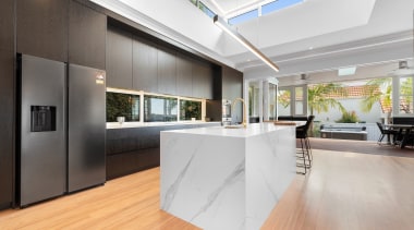 The chunky marble-look island is the kitchen's leading 