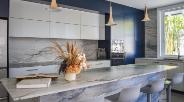 The kitchen's aesthetic comprises dark blue and grey 