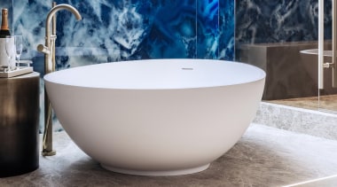 The egg-shaped tub anchors the wet area space, 