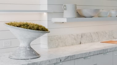 White wall-mounted shelving contrasts and complements freestanding shelving 