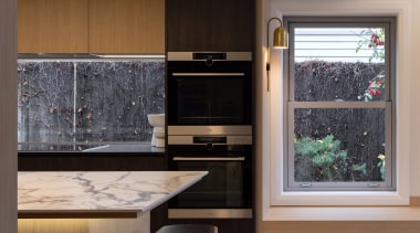 A glass window splashback plays natural light on 