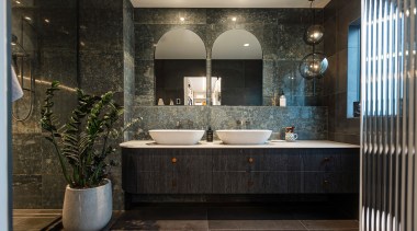 The bathroom has a moody meets natural vibe. 