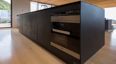 The main black surface is viewed on entering floor, flooring, furniture, wood, black, brown