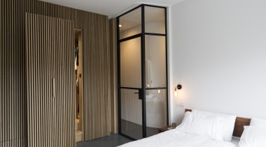 ​​​​​​​Sitting in between two bedrooms on this apartment’s bed, bedroom, door, floor, furniture, house, interior design, Cantero Architecture