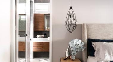 ​​​​​​​Pale wall and floor tones let the timber bed, bedroom, beige, floor, flooring, furniture, home, house, interior design, concrete flooring, light fixture, lighting, bedroom, table, wood, Dalecki Design