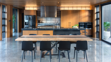 ​​​​​​​This kitchen by Kitchen Architecture presents as a architecture, bar stool, building, cabinetry, ceiling, countertop, dining room, floor, flooring, furniture, hardwood, home, house, interior design, kitchen, material property, property, real estate, room, table, wood, gray