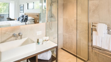 ​​​​​​​Clean-lined and contemporary, this custom steel-framed vanity is apartment, architecture, bathroom, beige, building, ceiling, floor, flooring, furniture, home, house, interior design, material property, plumbing fixture, property, real estate, room, tile, white, orange