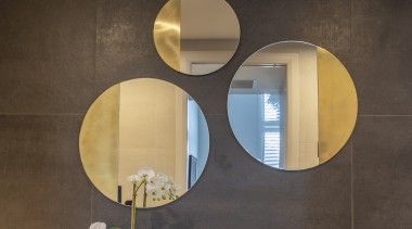 The three circular wall mirrors are framed in 