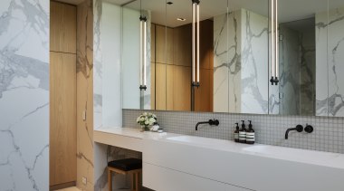 ​​​​​​​A room-length vanity is matched with mirror-front wall 
