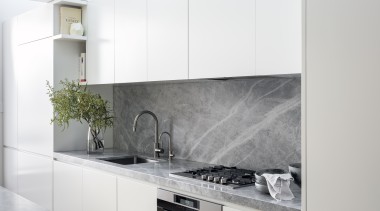 This white kitchen’s benchtops and splashback are in 