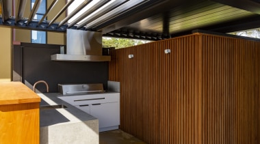 The outdoor kitchen with operable louvres overhead. 