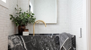 A limestone vanity, marble mosaics and brass tapware 