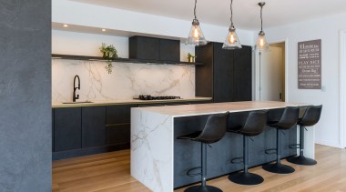 A slender waterfall benchtop adds to the kitchen's 