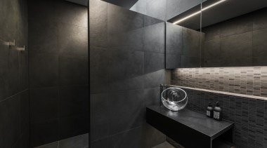 Designer Davinia Sutton created a moody space with architecture, bathroom, building, floor, flooring, house, interior design, material property, plumbing fixture, property, room, tile, wall, black