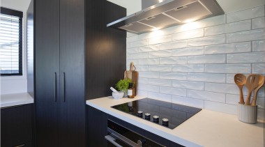 Pared back black cabinetry is teamed with textured 