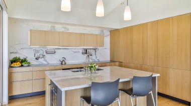 Understated contemporary pendants hang above the versatile island 