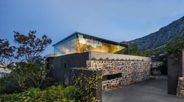 The home's inverted glass pyramid rises above privacy-bringing 