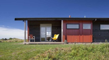 Exterior view of red wall and yellow folding-chair cottage, facade, home, house, property, real estate, shack, shed, sky, blue